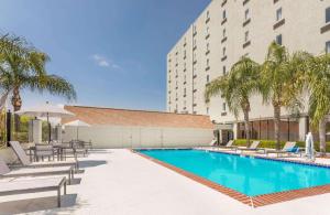 a swimming pool with chairs and a building at Best Western New Orleans East in New Orleans