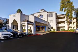 two cars parked in a parking lot in front of a building at Motel 6-Sunnyvale, CA - North in Sunnyvale