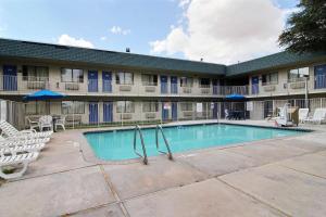 una piscina frente a un edificio con sillas en Motel 6-Fort Stockton, TX, en Fort Stockton