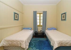 two beds in a room with a window at Torquay Treasure in Torquay