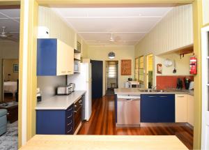 a kitchen with blue and white cabinets and wooden floors at Torquay Treasure in Torquay +17 photos
