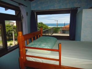 1 dormitorio con litera y ventana grande en Santinho Hostel, en Florianópolis