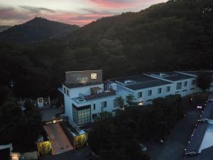 a large white building in front of a mountain at Hotel Gendairakuen Isehara in Isehara