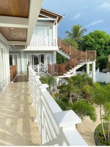 a balcony of a house with stairs and trees at Oasis Tolú Hotel Boutique in Tolú