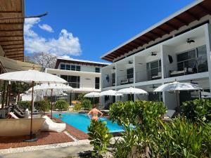 a person in a swimming pool next to a hotel at Ride On Beach House in Nosara