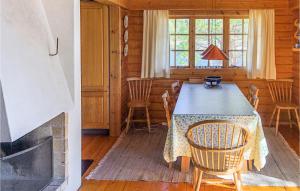 ein Esszimmer mit einem Tisch, Stühlen und einem Kamin in der Unterkunft Amazing Home In Krager With 4 Bedrooms in Kragerø