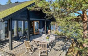 a wooden deck with a table and chairs on it at Amazing Home In Krager With 4 Bedrooms in Kragerø