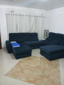 盧薩卡的住宿－Salama House，客厅配有蓝色的沙发和桌子