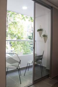 a glass door with a chair and a window at Espectacular apartamento Duplex VIP 501 con jacuzzy in Sabaneta