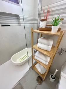a bathroom with a shower and a toilet and towels at Grupo Morgado - Quinta do Morgado - Morgado House in Tavira