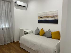 ein Schlafzimmer mit einem Bett mit gelben und grauen Kissen in der Unterkunft CASA DA PRAIA DA POÇA - APARTAMENTO LÍRIO in Estoril