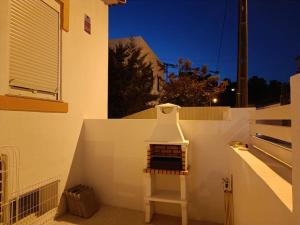 eine weiße Treppe mit einer Vase an der Seite eines Gebäudes in der Unterkunft CASA DA PRAIA DA POÇA - APARTAMENTO LÍRIO in Estoril