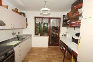 a kitchen with white cabinets and a large window at Holiday home in Loka pri Zusmu Stajerska Untersteiermark 26086 in Loka pri Žusmu