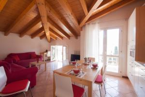 a living room with a table and red chairs at Casa del Sole - sleeps 4 with shared pool in Pianello Del Lario