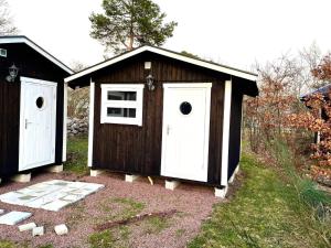 uma casa de cães castanho e branco com duas portas em Holiday home ROCKNEBY III em Rockneby