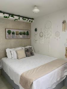 1 dormitorio con 1 cama grande con plantas en la pared en APARTASUITES CON VISTA AL MAR en Cartagena de Indias