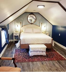 a bedroom with a large bed and a mirror at South Court Inn in Luray