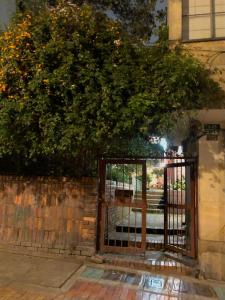 an open gate with an orange tree behind it at Magdalena Guest House in Bogotá