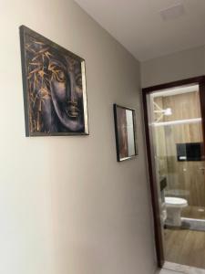 a bathroom with a painting on the wall and a mirror at Apartamento c/ piscina , Praia do Francês. in Marechal Deodoro