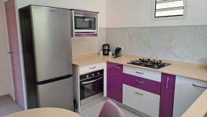 a kitchen with purple cabinets and a refrigerator at Résidence Paradis in Petit-Bourg