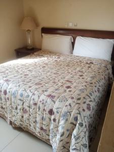 a bedroom with a bed with a quilt on it at International Hotel, Yaoundé in Yaoundé