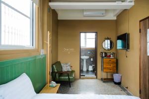 una camera da letto con un letto, una sedia e uno specchio di Xin Yuan Hang Homestay a Guanshan