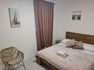 a bedroom with a bed with a chair and two towels at Apartments by the sea Nevidjane, Pasman - 8453 in Neviđane