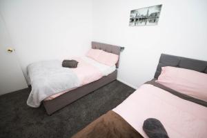 #Gorgeous 3 beds home#7min to subway, free parking في Thamesmead: غرفة نوم بسريرين وصورة على الحائط
