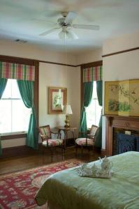 a bedroom with a green bed and a fireplace at Lookaway Inn in North Augusta