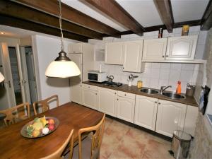 a kitchen with a table with a bowl of fruit on it at Beautiful holiday home with private pool in Lusignac