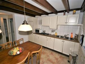 a kitchen with a table with a bowl of fruit on it at Spacious holiday home with pool in Lusignac in Bouteilles-Saint-Sébastien