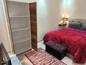 sypialnia z czerwonym łóżkiem i czerwonym kocem w obiekcie magnifique appartement à rabat proche de la mer w mieście Rabat