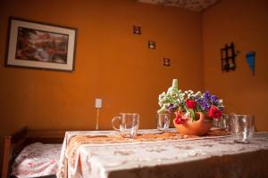 una mesa con un jarrón de flores. en Departamento Inti Raymi en Tilcara