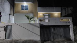 una casa con una valla blanca y un edificio en Sleep Well Salvador, en Salvador