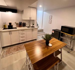 cocina con armarios blancos y mesa de madera en The Boho Oasis, en Windsor