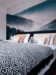 1 dormitorio con 2 camas y una pintura de un bosque en Elias im Landhausstil en Bayreuth