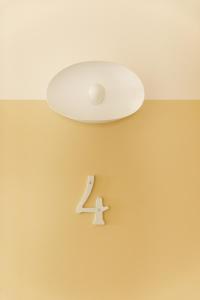 a ceiling light with a number four on a wall at Petit hôtel de la Montagne in Havre-Aubert