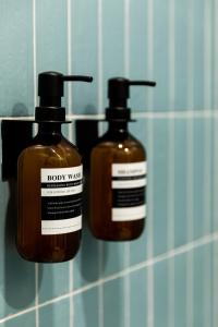 two bottles of soap on a bathroom wall at Petit hôtel de la Montagne in Havre-Aubert