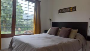1 dormitorio con cama grande y ventana grande en Huala Patagonico en San Carlos de Bariloche