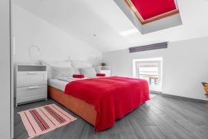 a white bedroom with a red blanket on a bed at Apartments by the sea Punat, Krk - 20527 in Punat