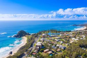 eine Luftblick auf einen Strand mit Häusern und das Meer in der Unterkunft Seaside Serenity~GamesRoom~HotSpa! in Port Macquarie