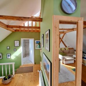 una sala de estar con paredes verdes y vigas de madera. en Entire Loft close to Beautiful Logar Valley en Rečica ob Savinji