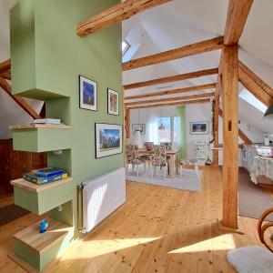 a living room with green walls and wooden beams at Entire Loft close to Beautiful Logar Valley in Rečica ob Savinji