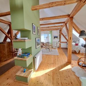 a living room with a green wall and wooden floors at Entire Loft close to Beautiful Logar Valley in Rečica ob Savinji