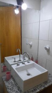 DEPARTAMENTO URBANO EL CHALLAO في ميندوزا: حمام مع حوض أبيض ومرآة