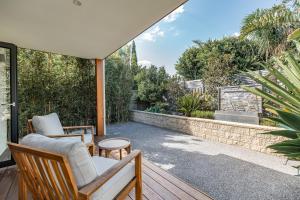 a patio with two chairs and a table at Earimil Villas - Waterfront in Mount Eliza