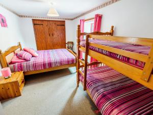 a bedroom with two bunk beds and a window at Pine Cottage - Rchp140 in Calton