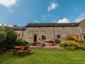 ein Steinhaus mit einem Picknicktisch im Hof in der Unterkunft Pine Cottage - Rchp140 in Calton