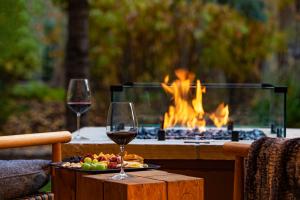 dos copas de vino en una mesa frente a una hoguera en The Hythe, a Luxury Collection Resort, Vail, en Vail