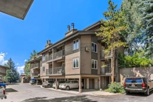 um edifício de apartamentos com carros estacionados num parque de estacionamento em Easy Walk to Gondola-Elegant-Sunny-Updated Condo em Steamboat Springs